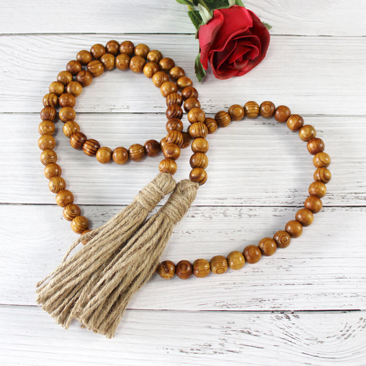 CVHOMEDECO. Wood Grain Beads Garland with Tassels Farmhouse Rustic Wooden Prayer Bead String Wall Hanging Accent for Home Festival Decor. Brown
