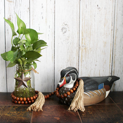 CVHOMEDECO. Wood Grain Beads Garland with Tassels Farmhouse Rustic Wooden Prayer Bead String Wall Hanging Accent for Home Festival Decor. Dark Brown